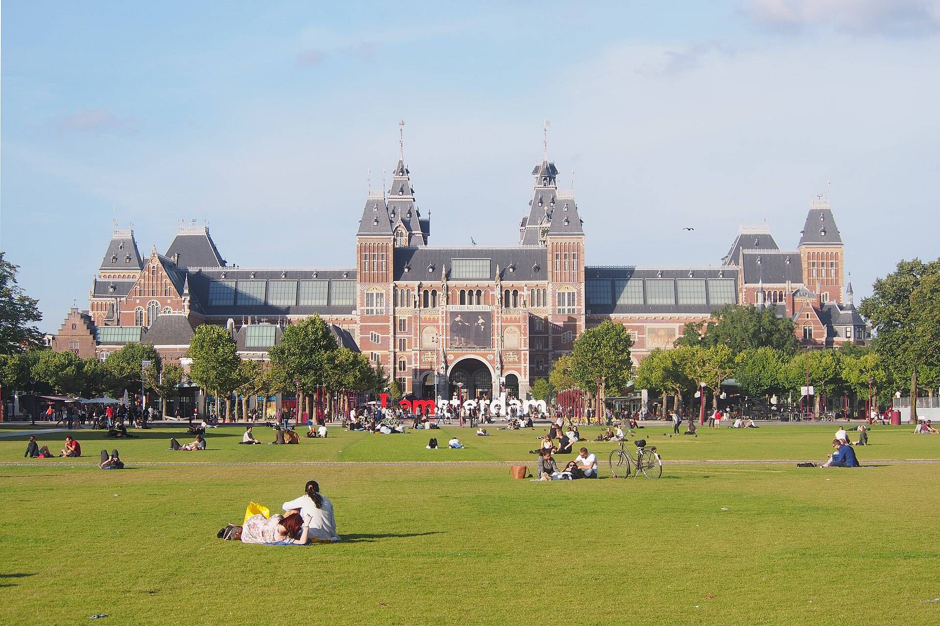 Das Rijksmuseum in Amsterdam hinter der Sommerwiese des Museumplein