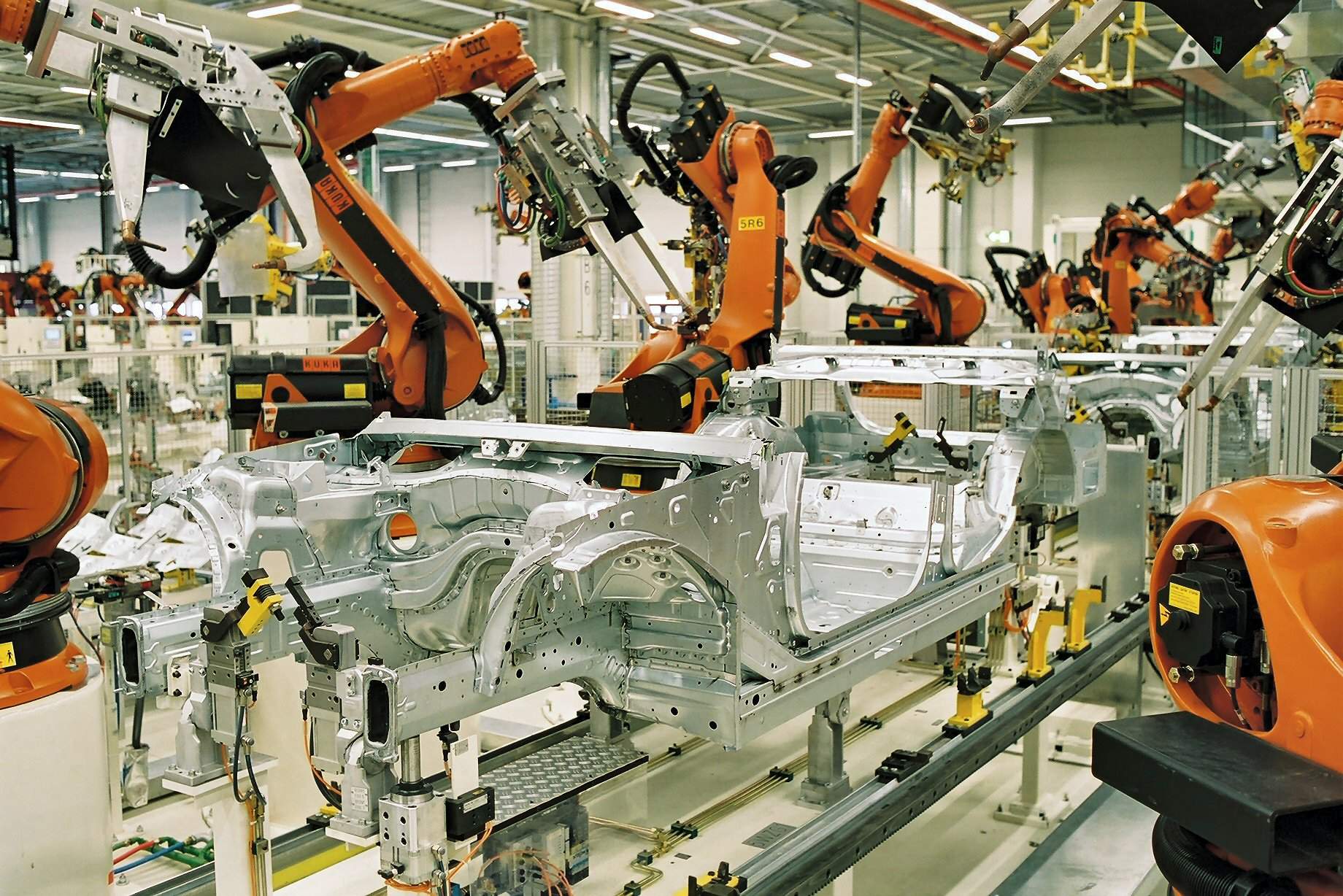 Industrieroboter schweißen eine Karosserie im Rohbau eines Automobilwerks