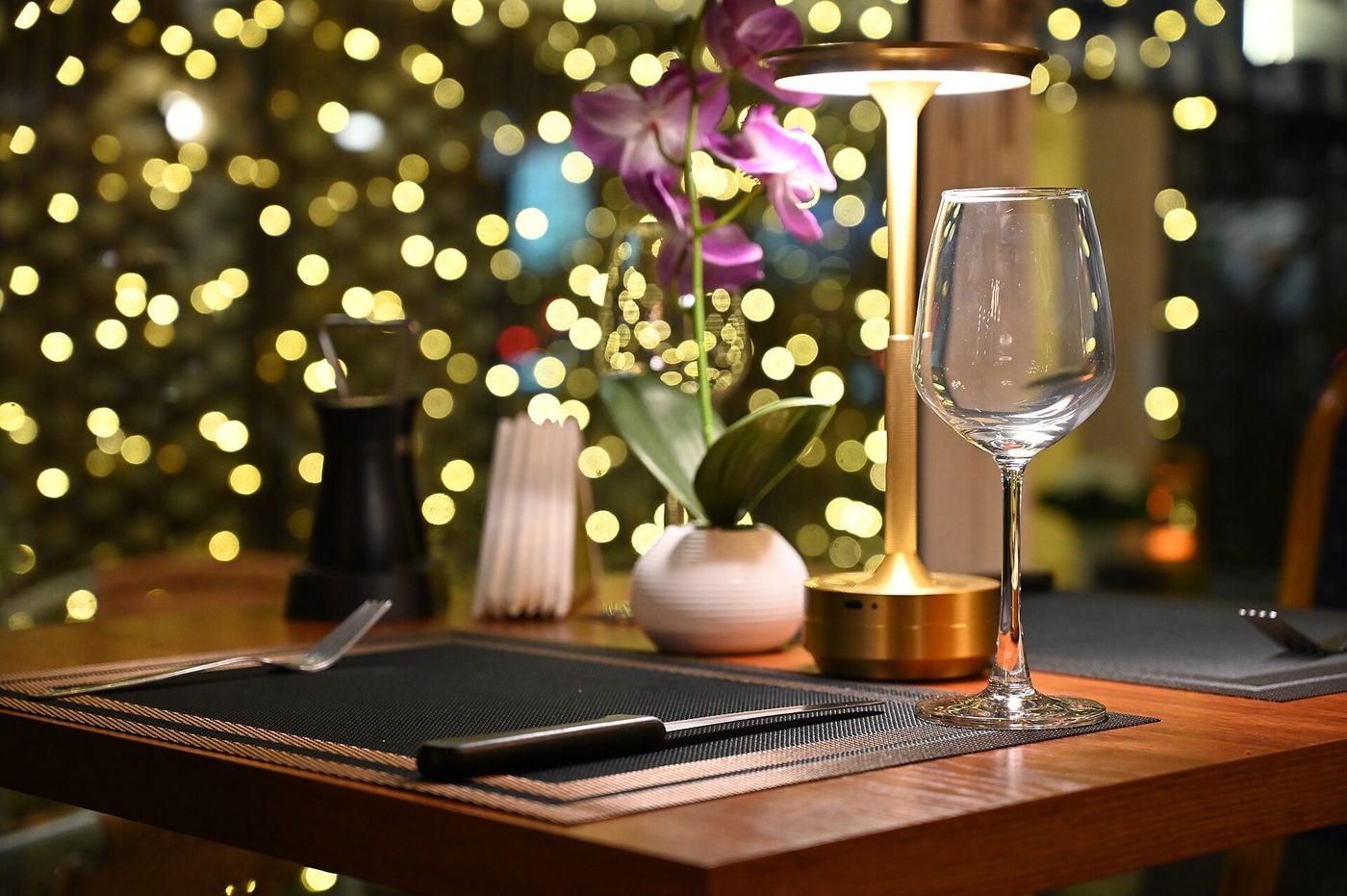 Gedeckter Abendtisch mit Weinglas und Tischleuchte