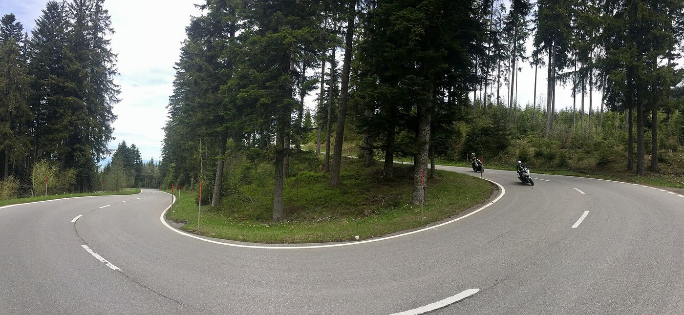 Zwei Motorradfahrer in einer Spitzkehre einer Passstraße